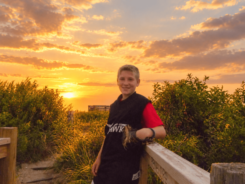 Giovanni Cipriano smiling with his baseball glove at sunset